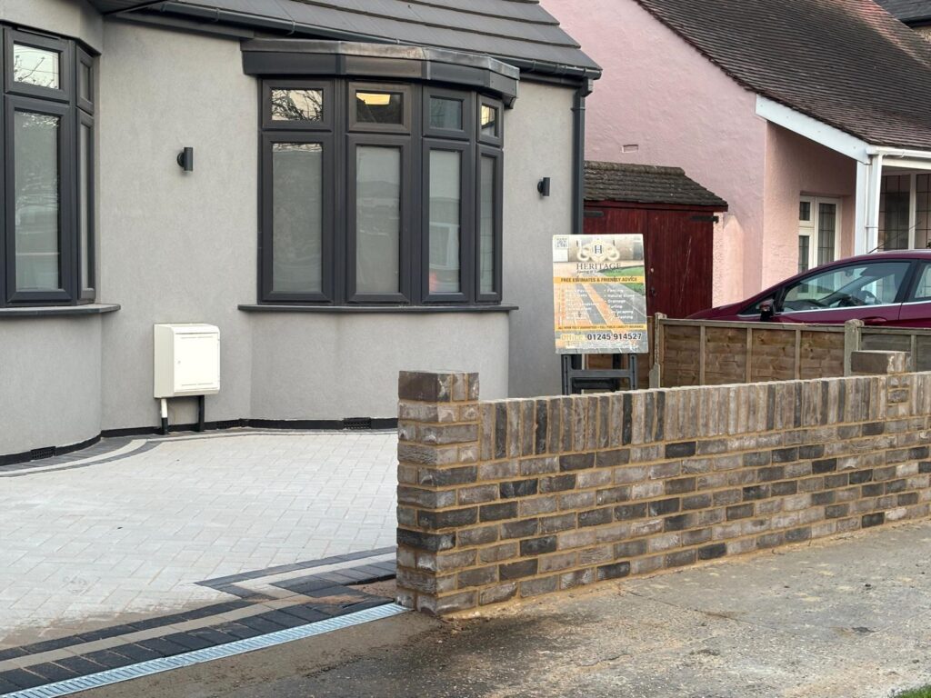 New driveway with light grey paving and brick retaining wall – Essex property improvement
